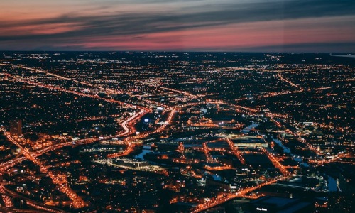 sweeping view from a Chicago rooftop bar at sunset, city lights beginning to twinkle, lake in the background - Rooftop terrace Chicago