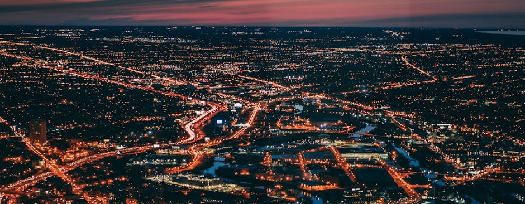 sweeping view from a Chicago rooftop bar at sunset, city lights beginning to twinkle, lake in the background - Rooftop terrace Chicago